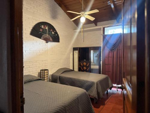 a bedroom with two beds and a ceiling fan at Bungalós brunos in Panajachel