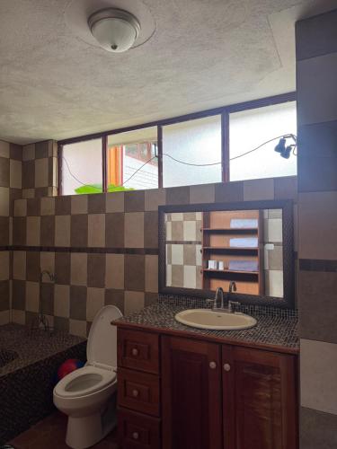 a bathroom with a sink and a toilet and a mirror at Bungalós brunos in Panajachel