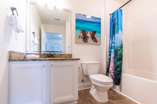 a bathroom with a toilet and a sink and a mirror at Hello Sunshine in Santa Rosa Beach