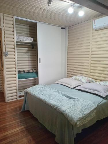 a bedroom with a large bed and a closet at CHALÉ ALPINO RAIZ TODO MOBILIADO COM 2 QUARTOS COZINHA SALA BANHEIRO NATUREZA 2 KM centro de Canela rs in Canela