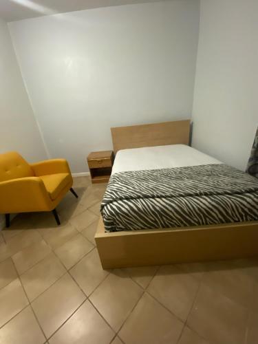 a bedroom with a bed and a yellow chair at private room in Paterson