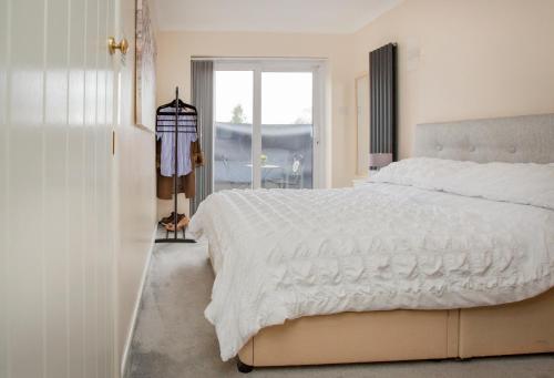 a bedroom with a large white bed and a window at The Annex @ 136 in Gloucestershire