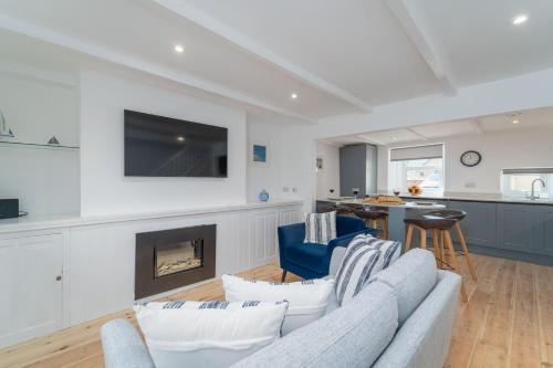a living room with a couch and a fireplace at Karibu - Boutique Cottage with Parking - Short walk to Beach in St Ives
