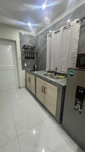a small kitchen with a sink and a refrigerator at Prestige Apartments C - Affordable Studio Near Sambil Shopping Mall with Fast WiFi in Willemstad