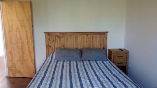 a bed with blue pillows in a bedroom at Cabaña DEK in Tigre