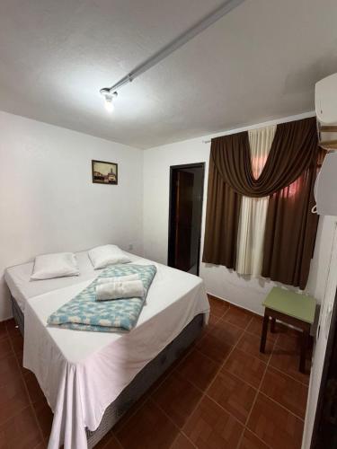 a bedroom with a bed and a window at Hotel Kika in São Gabriel