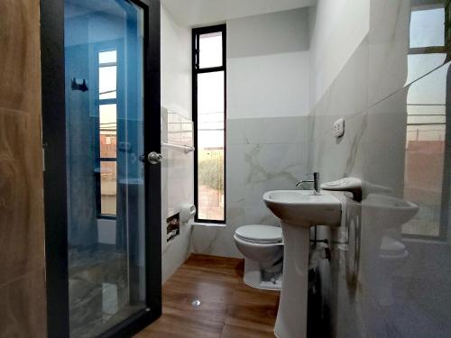 a bathroom with a sink and a toilet at Hostal Huella in Lambayeque