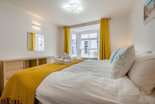 a bedroom with a large white bed with yellow curtains at 2 Bed in St. Ives oc-e28156 in St Ives