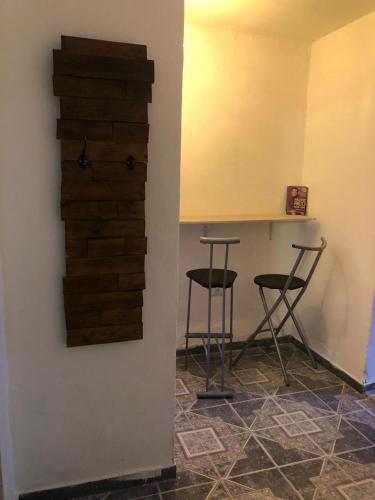 two bar stools and a counter in a room with a wall at Espacio Marea in Puerto Madryn