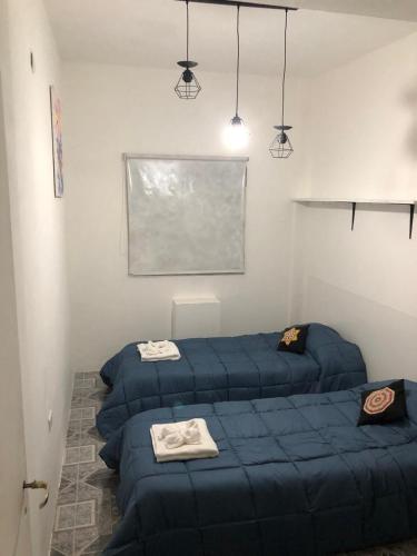a room with two blue beds in a room at Espacio Marea in Puerto Madryn
