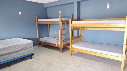 a room with three bunk beds and a blue wall at Diony in Brotas