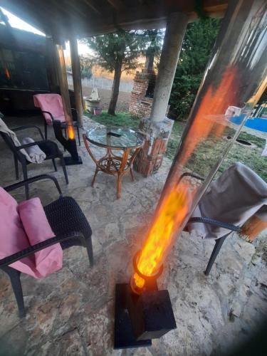 a fire pit in a patio with chairs and a table at Villa Dalmatina with pool in Kumanovo
