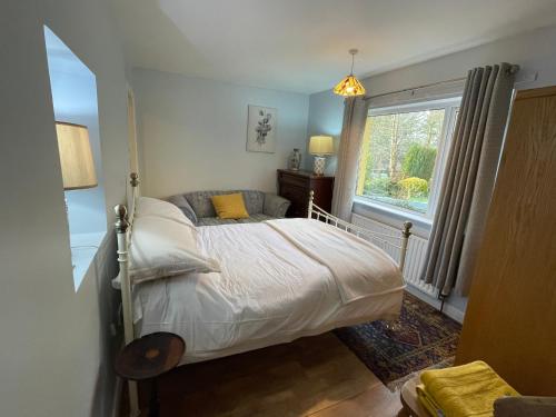 a bedroom with a bed and a window at Cloonaveel House in Letterbreen