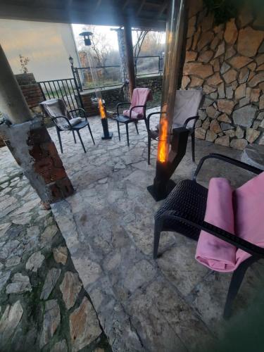 a group of chairs sitting on a stone patio at Villa Dalmatina with pool in Kumanovo