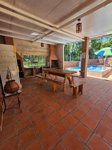 Un patio con una mesa de ping pong y una sombrilla. en Hospedaje 63, en Caacupé