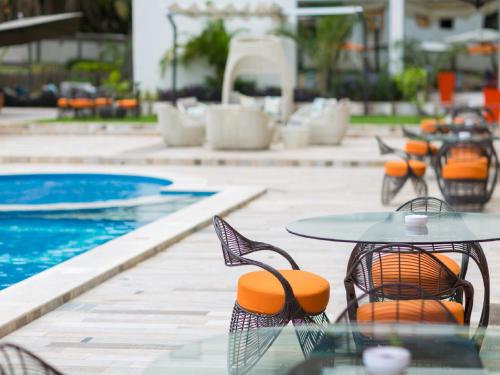 a table and chairs next to a swimming pool at The Palms by Eagles in Takoradi