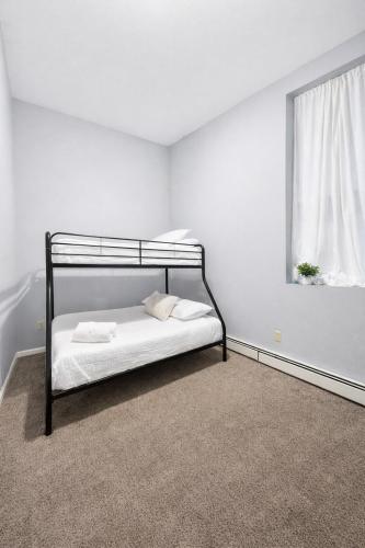 a bedroom with a black bunk bed with a window at Escape your everyday in your COZY HIDEAWAY Feel right at home Relax recharge & unwind in Troy