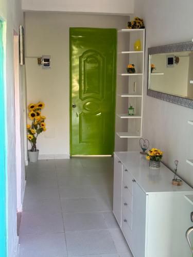 a green door in a white kitchen with a counter at Rancho Doña Rita in Higuey