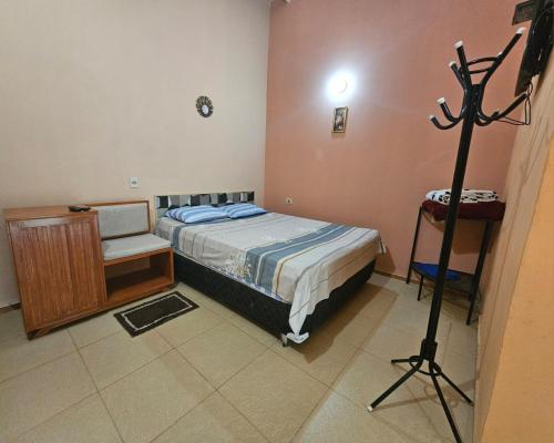 Un dormitorio con una cama y un trípode dentro. en Hospedaje 63, en Caacupé