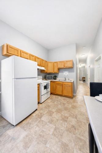a kitchen with a white refrigerator and wooden cabinets at Escape your everyday in your COZY HIDEAWAY Feel right at home Relax recharge & unwind in Troy