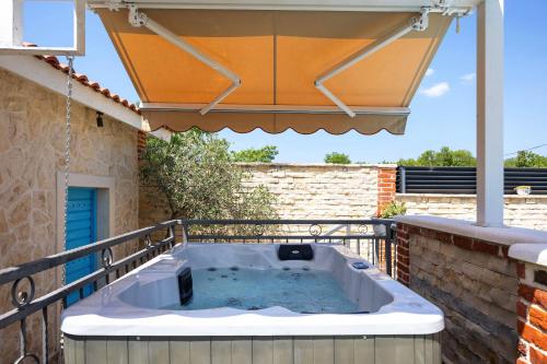 a hot tub on a balcony with an umbrella at Villa Peaceful Valley in Šestanovac
