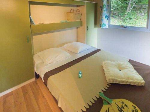 a small bedroom with a bed with a largeigunigunigun at Chalet 5 Pers avec Terrasse - API-1-52-1125 in Vendoire