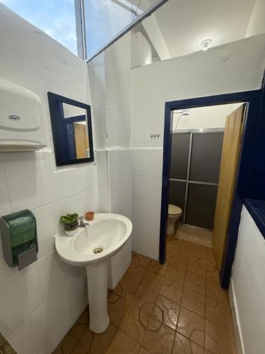 a white bathroom with a sink and a toilet at Refúgio Colonial 3 - Antonio Dias in Ouro Preto