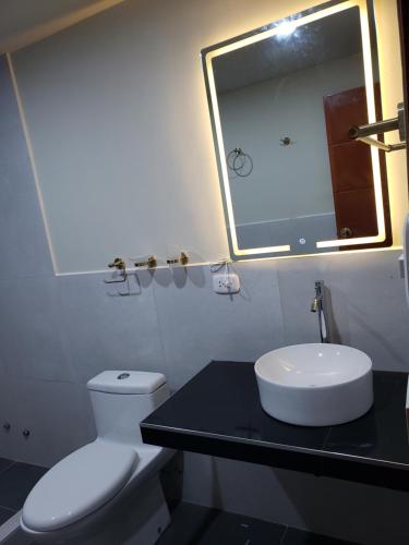 a bathroom with a white toilet and a sink at Top Manu Avatar Lodge in Pillcopata