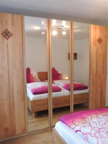 1 Schlafzimmer mit 2 Betten und einem Spiegel in der Unterkunft Ferienhaus Snevern in Schneverdingen