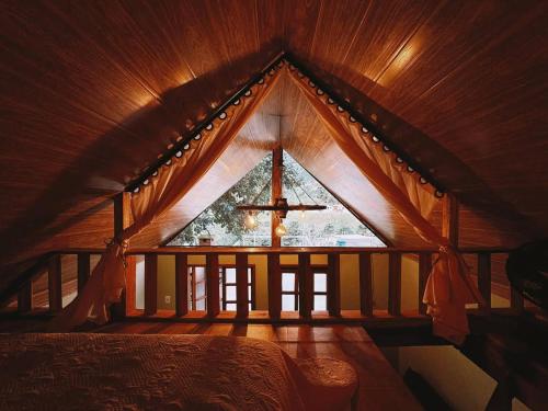 a large window in a wooden room with a bed at Bangalo Bela Vista in Caparaó Velho