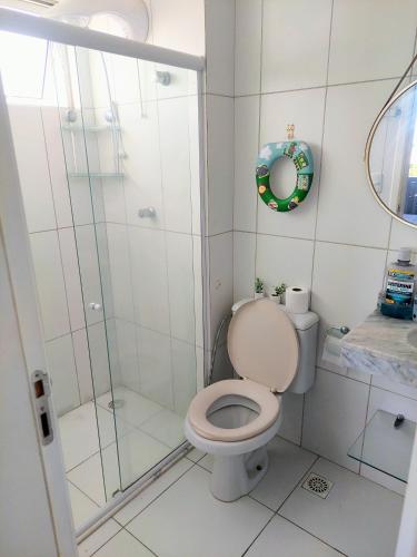 a bathroom with a toilet and a glass shower at Residencial Clube Recanto dos Coqueiros in Aracaju