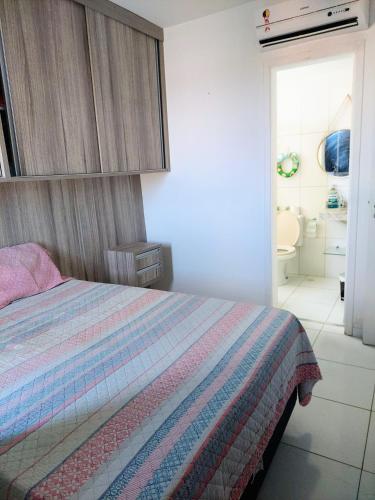 a bedroom with a bed and a bathroom at Residencial Clube Recanto dos Coqueiros in Aracaju