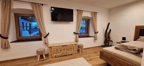 a bedroom with a bed and a tv on the wall at alter Hannelerhof in Mutters