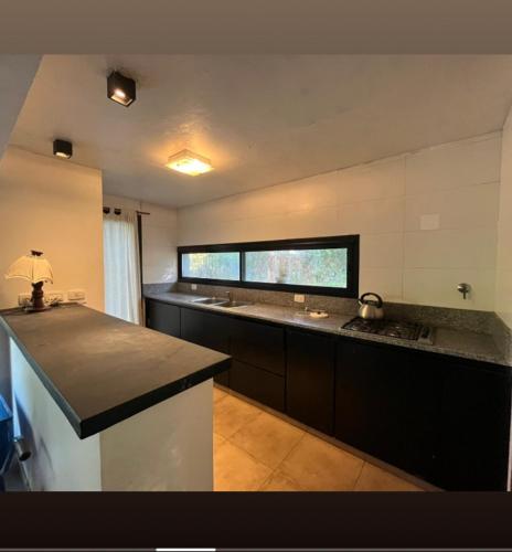 a large kitchen with a counter and a sink at Quinta con pileta in Brandsen