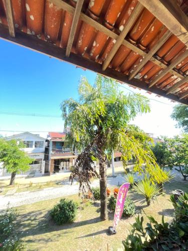 a tree in a yard with a surfboard under a roof at Apartamento Rangel in Cairu