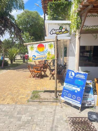 a sign in front of a restaurant with a table at Apartamento Rangel in Cairu