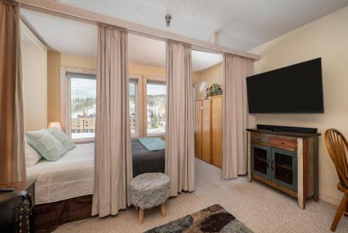 a bedroom with a bed and a flat screen tv at Snowblaze E102 Studio in Winter Park