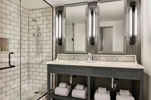a bathroom with a sink and a shower at Lido House, Autograph Collection in Newport Beach