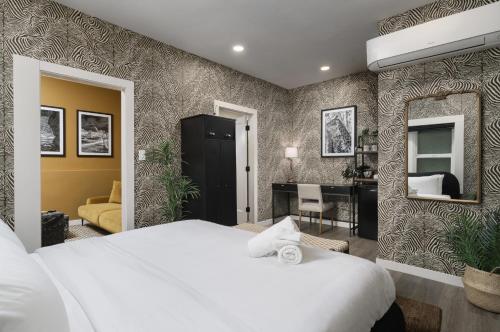 a bedroom with a white bed and a mirror at Hotel Zindel in San Diego