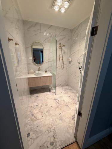 a bathroom with a shower and a sink and a mirror at Tily's Place in Parkes