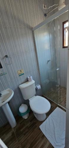 a bathroom with a toilet and a sink and a shower at Pousada Encontro das Águas in Trindade