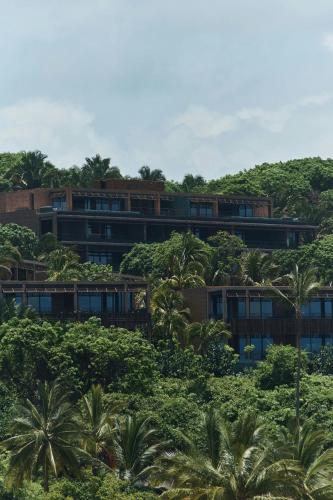 an apartment building on top of a hill with trees at Siari Riviera Nayarit, a Ritz-Carlton Reserve in El Divisadero