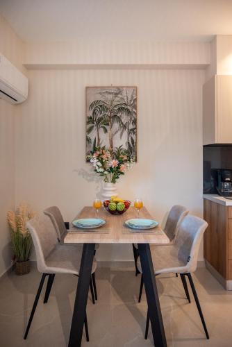 a dining room table with chairs and a bowl of fruit on it at Mystrali 1BD Modern Apt with Private Garden in Galatás