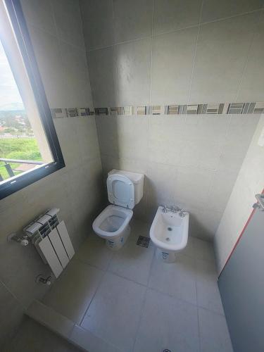 a small bathroom with a toilet and a sink at Triplex con vista hermosa in Salta
