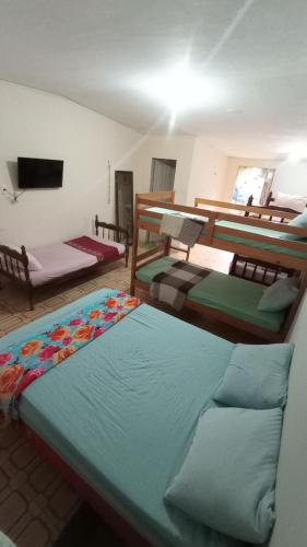 ein Zimmer mit drei Etagenbetten und einem Fernseher in der Unterkunft Agro Villa in Areia
