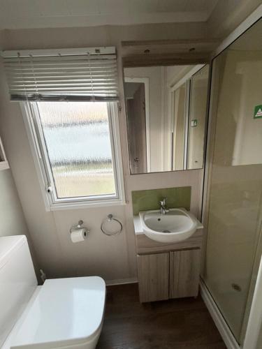 a bathroom with a toilet and a sink and a window at RelaxDream in Port Seton