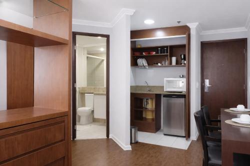 a small kitchen with a sink and a microwave at Flat com piscina no Jardim Paulista a 300m da Av Paulista e metrô in São Paulo