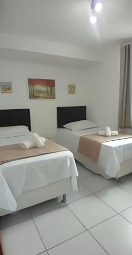 two beds in a room with white walls at Apartamento Completo 608 Monte Fuji, Praia de Cabo Branco in João Pessoa