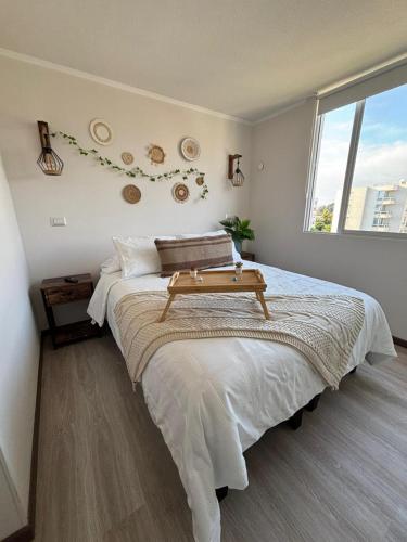 a bedroom with a large bed with a table on it at Apartment steps away from the beach in La Serena
