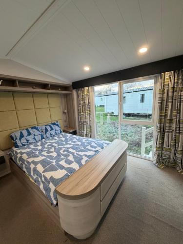 a bedroom with a large bed and a large window at RelaxDream in Port Seton